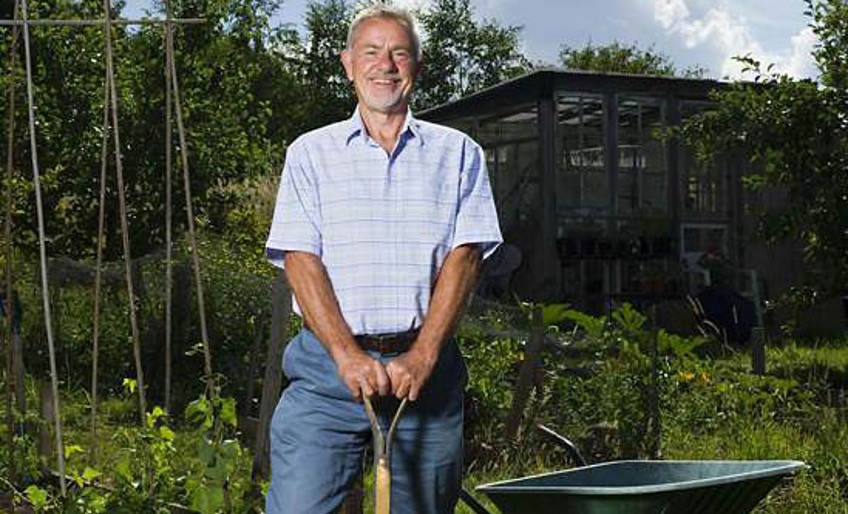 DEVK-Gartenhausversicherung - Mann steht mit Schaufel im Garten